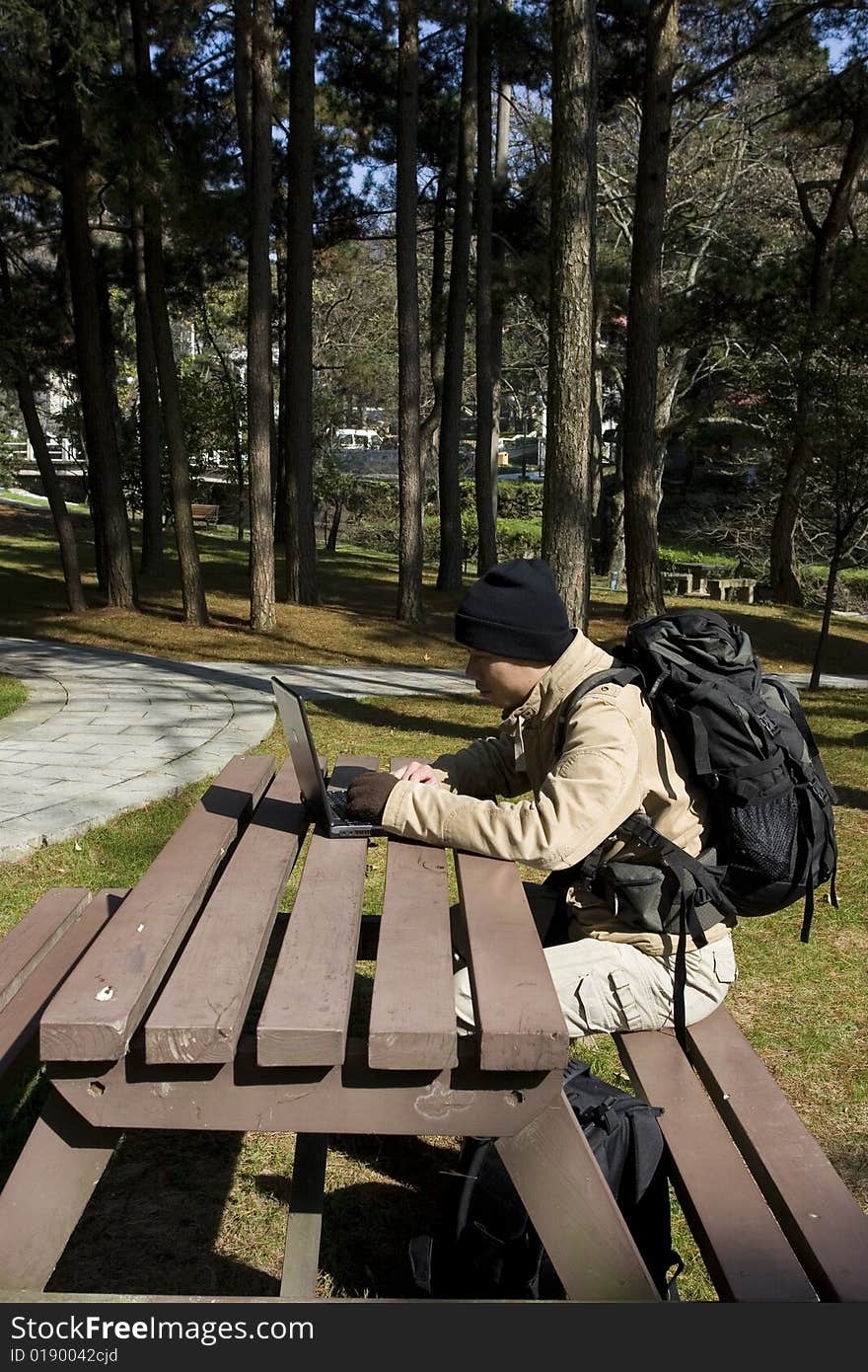 A hiker using a laptop outdoors