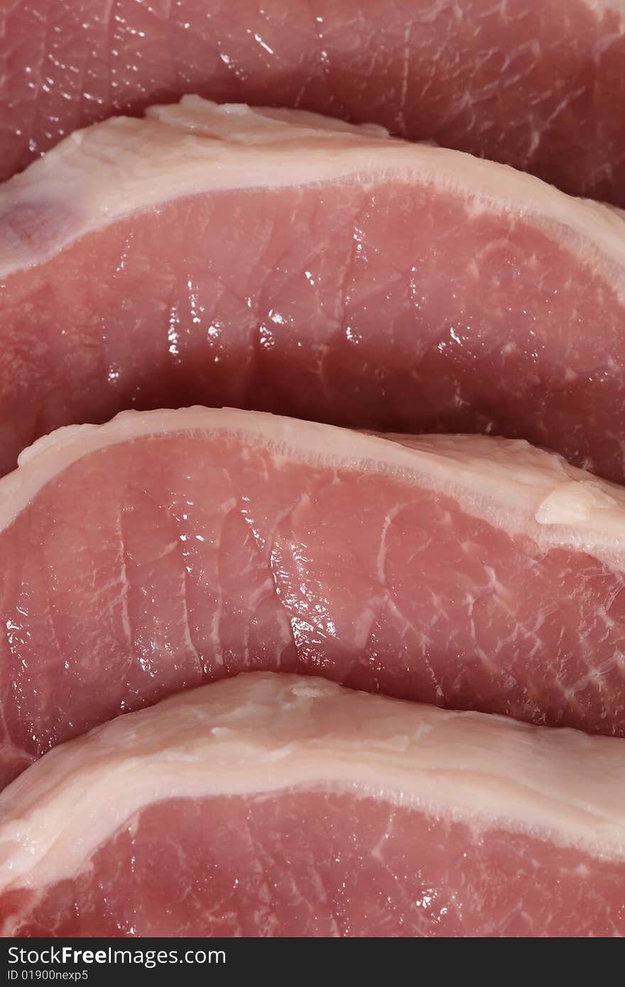 Four fresh pork steaks in detail view