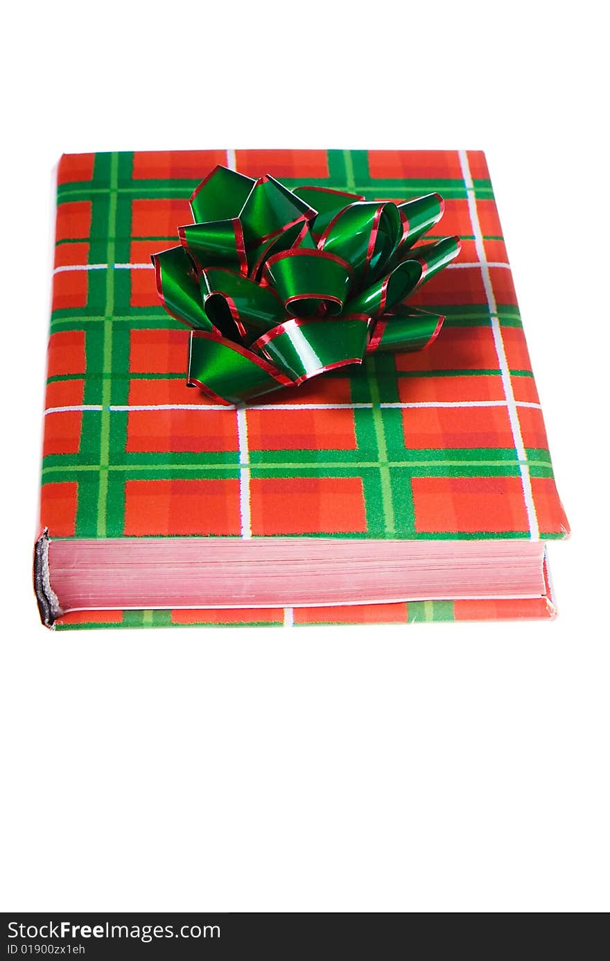 Book wrapped in traditional Christmas colors with red and green bow on top. Book wrapped in traditional Christmas colors with red and green bow on top