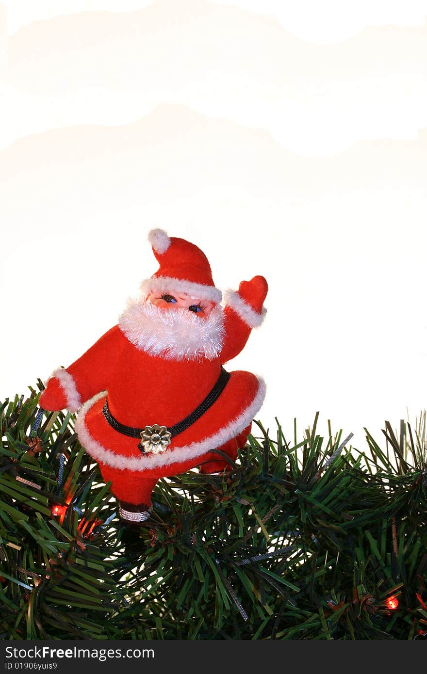 A jolly vintage Santa standing on an evergreen branch with room for copy. A jolly vintage Santa standing on an evergreen branch with room for copy.