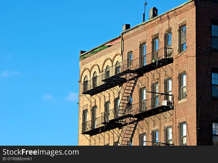 Fire escapes on old tenament buildings in boston massachusetts against a blue sky