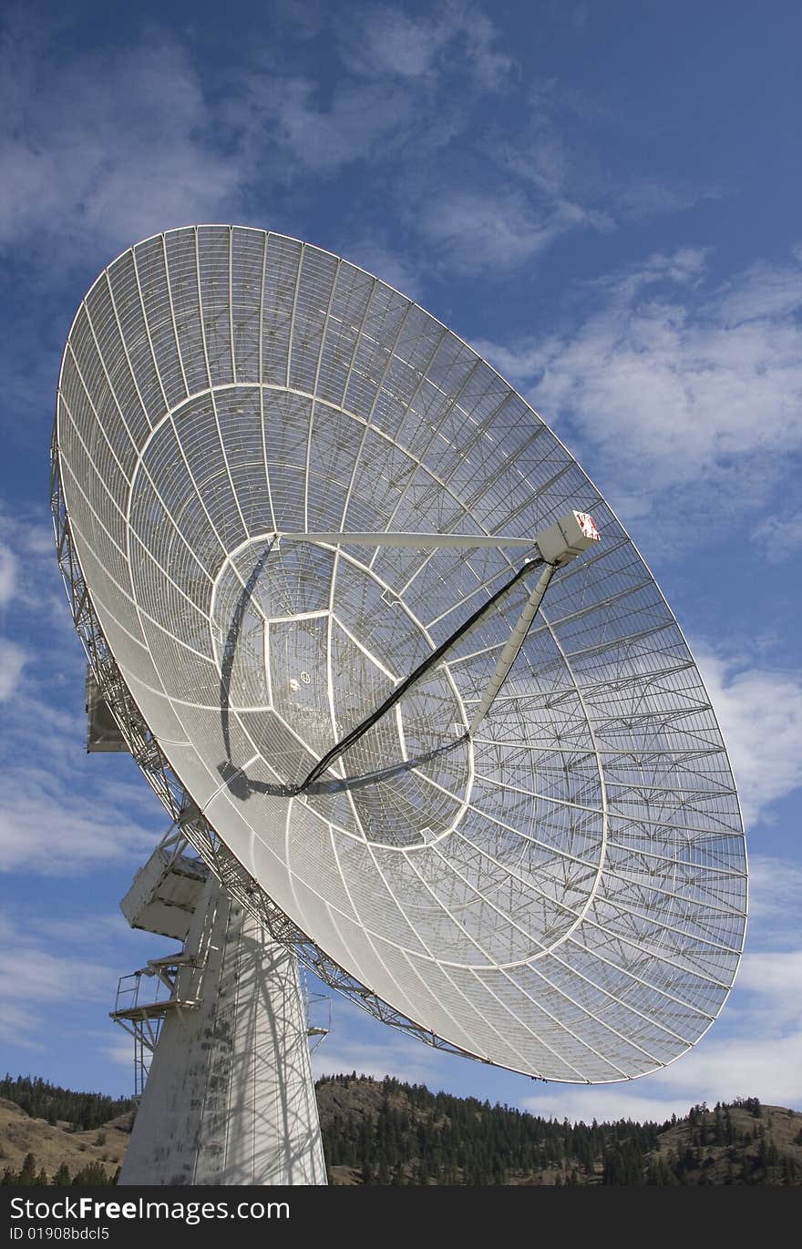 The open weave antenna dish and sturdy base of a large radio telescope.