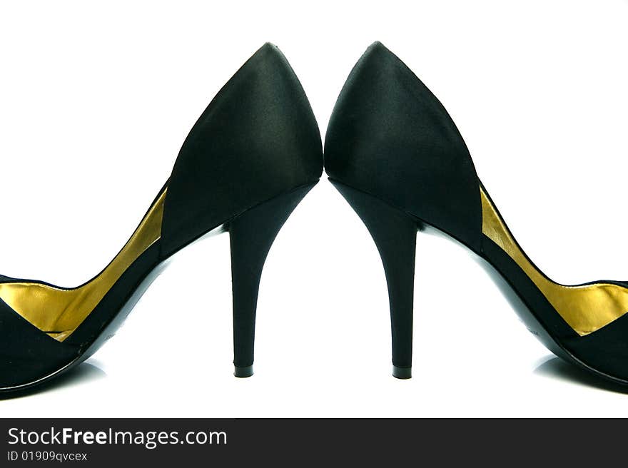 A pair of high heel shoes isolated against a white background. A pair of high heel shoes isolated against a white background