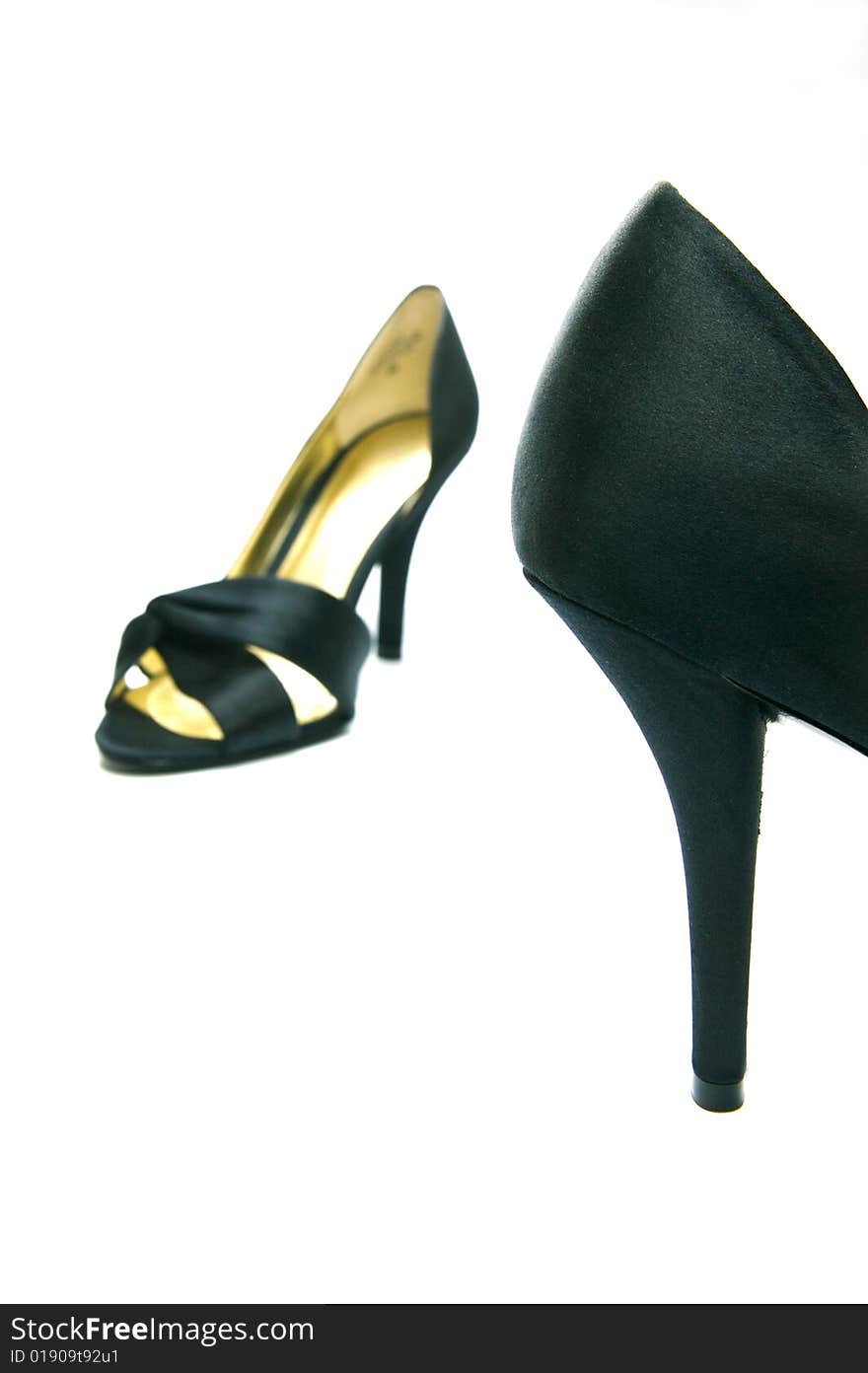 A pair of high heel shoes isolated against a white background. A pair of high heel shoes isolated against a white background