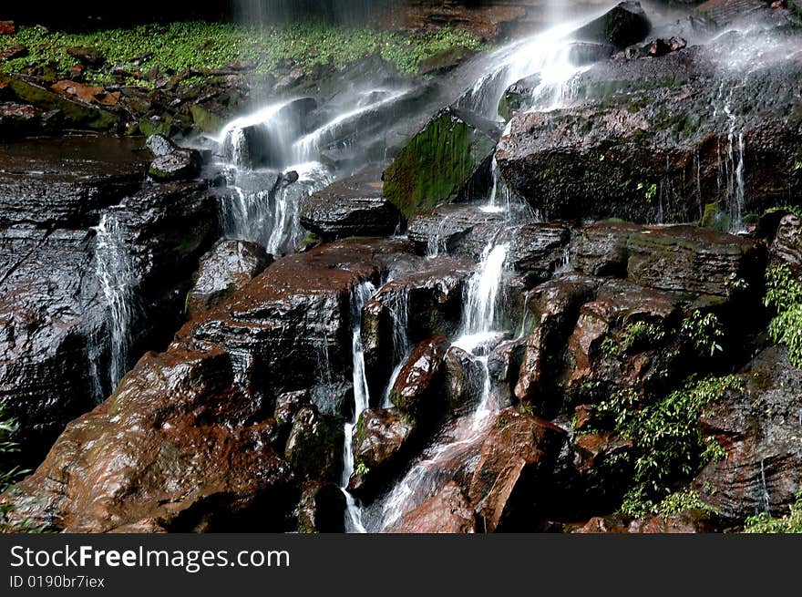 Water fall down to black rocks and spread all derections