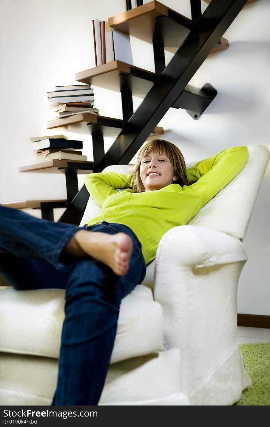 Portrait of young woman relaxing in chair at home. Portrait of young woman relaxing in chair at home