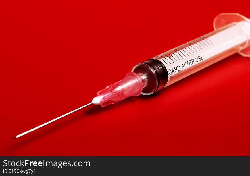 Empty red syringe on red