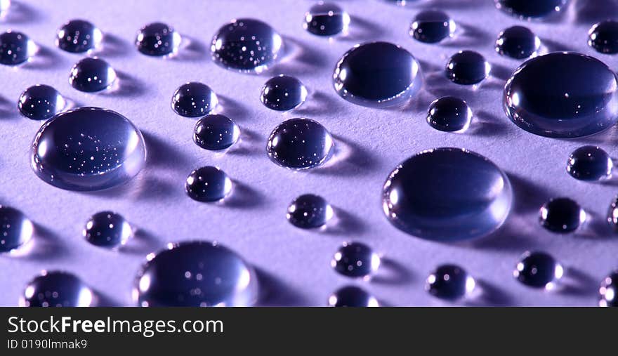 An image of water drops on violet background. An image of water drops on violet background