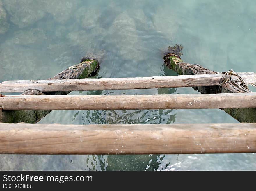 A wooden latter leads steeply into the ocean. A wooden latter leads steeply into the ocean