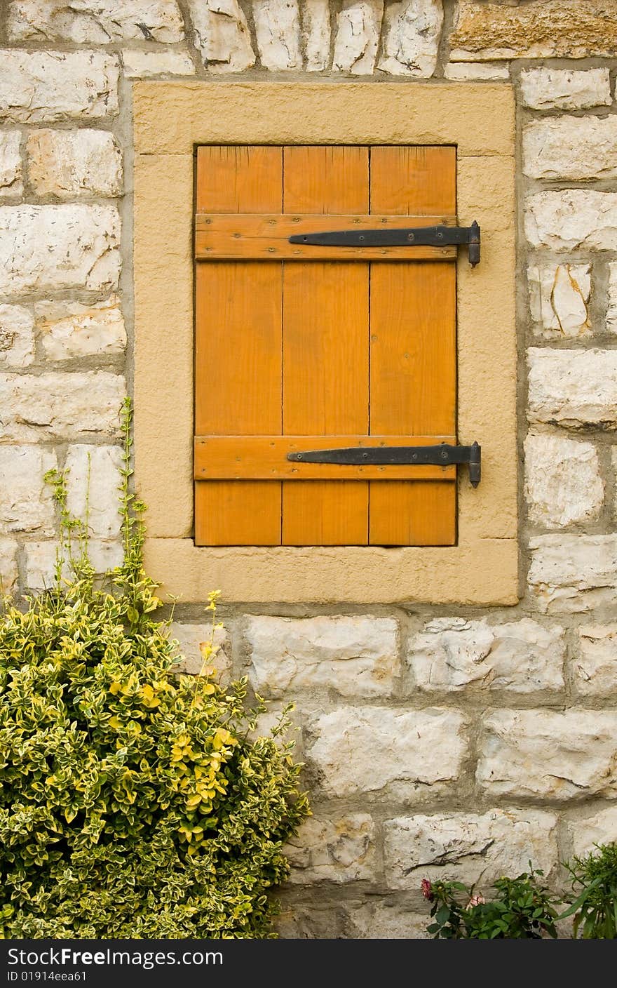 Closeup of window on the stone rural house wall closed with shutter. Closeup of window on the stone rural house wall closed with shutter