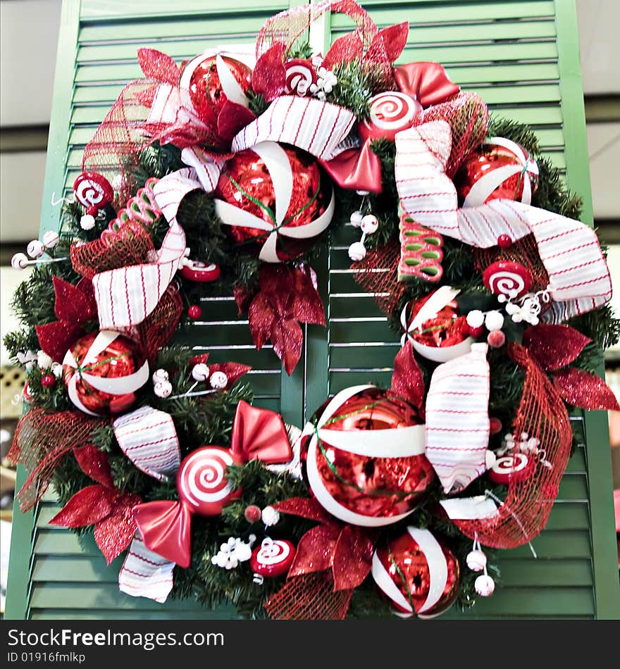 A red and white christmas wreath with ornaments