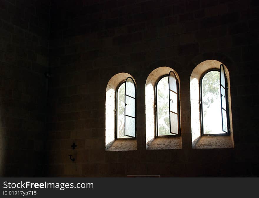 Trees discernible through the windows  in a church wall. Trees discernible through the windows  in a church wall