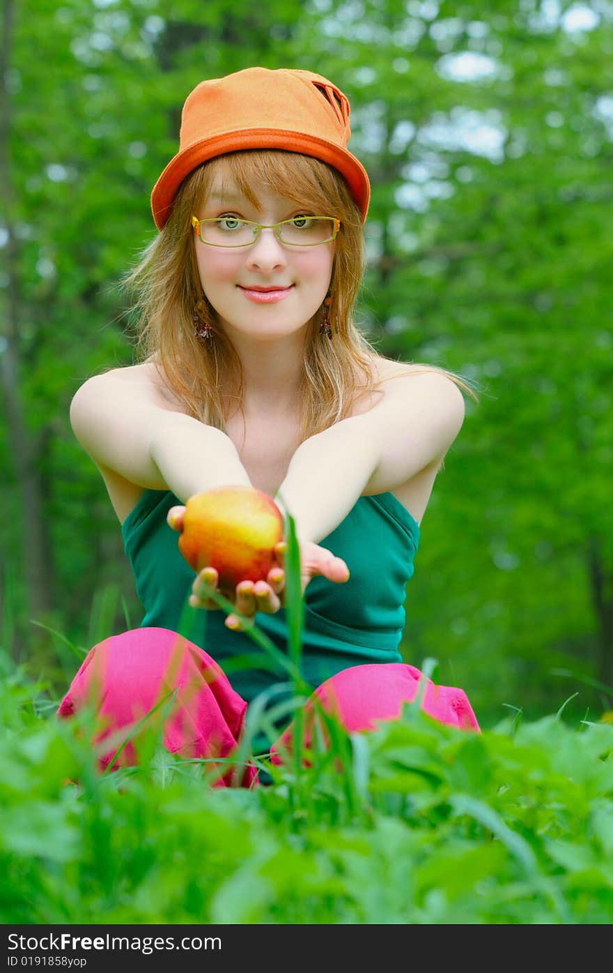 Girl in bonnet with apple outdoor