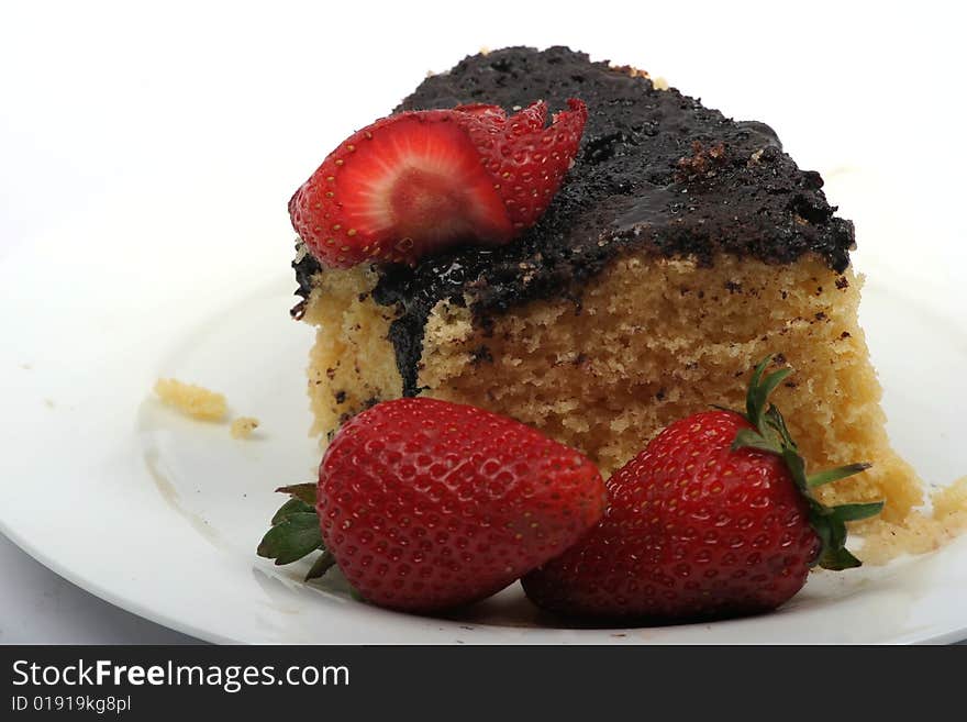 Strawberries and cake with chocolate icing on plate