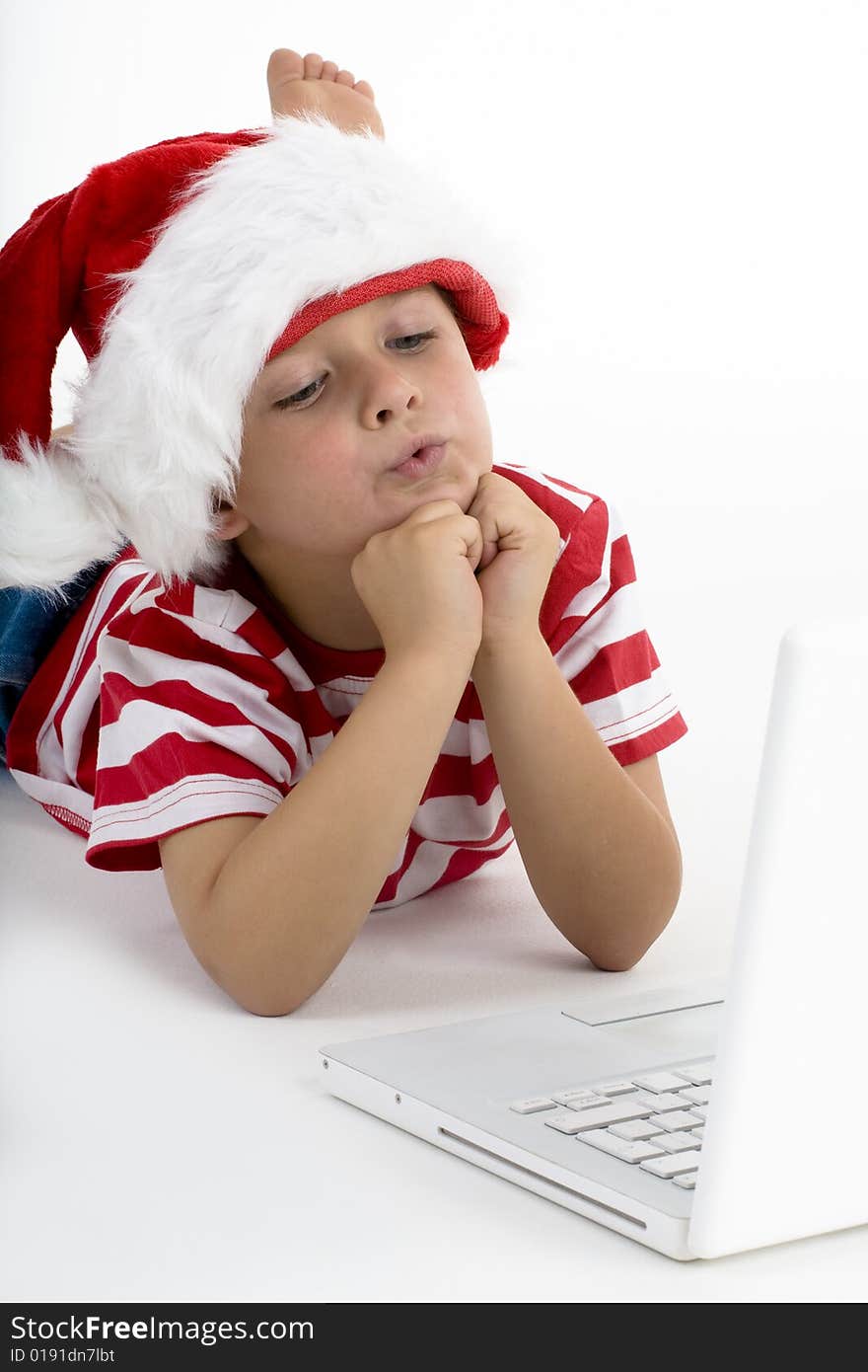 Young boy dressed as Santa's elve, ordering gift on laptop. Young boy dressed as Santa's elve, ordering gift on laptop