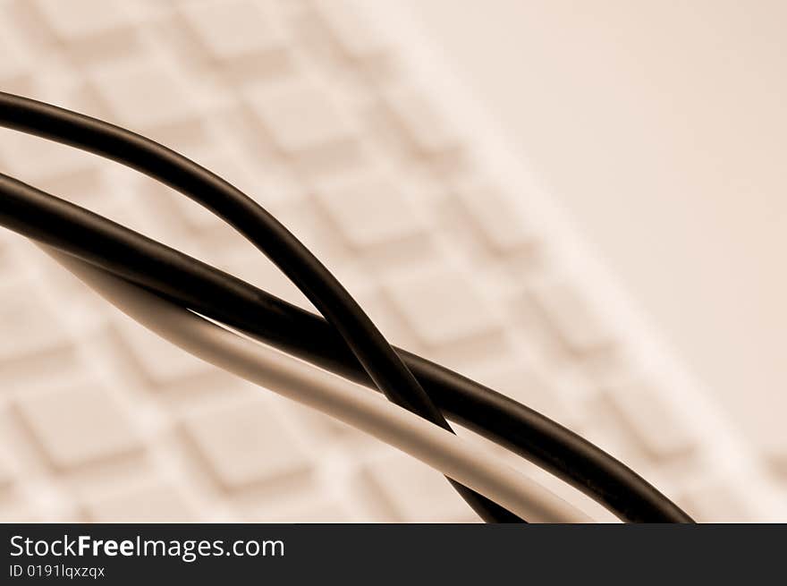 Computer cables over a blurry keyboard background. Computer cables over a blurry keyboard background