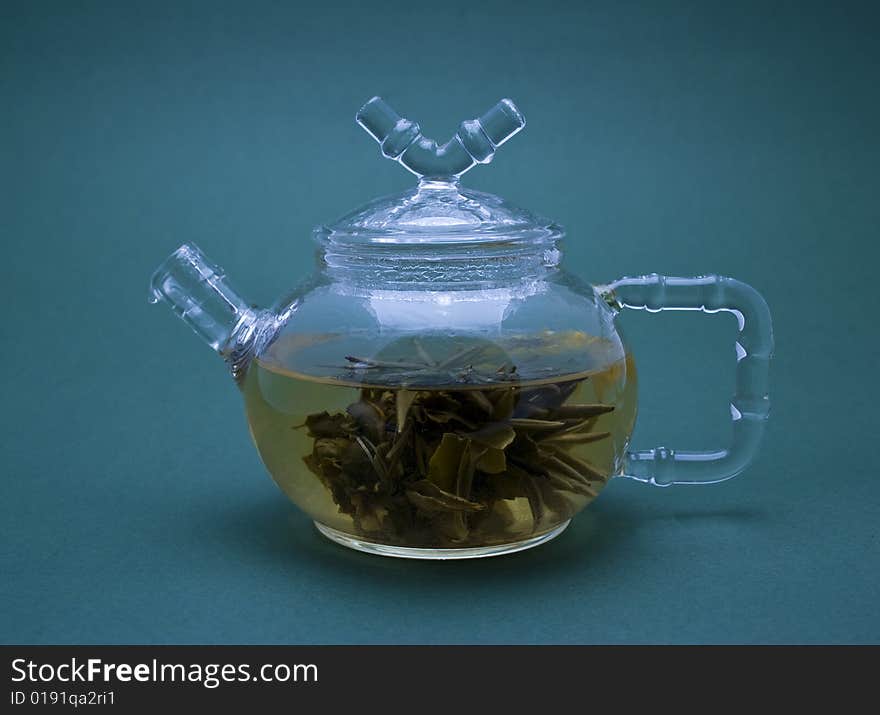 Teapot with tea close-up isolated on blue background