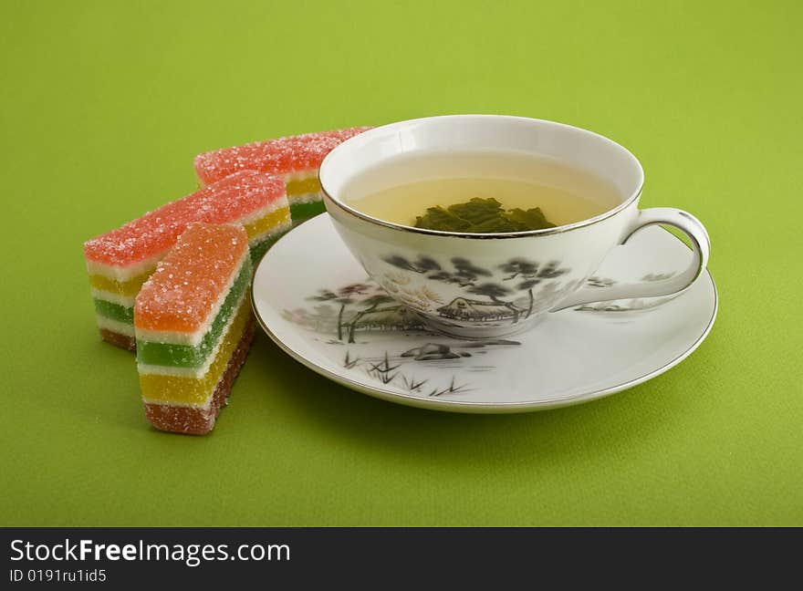 Tea cup and jellies close-up isolated