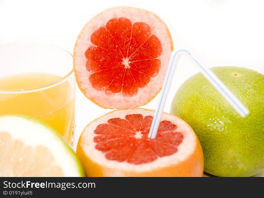 Citrus Fruits - res and green grapefruits, and glass of orange juice isolated on white