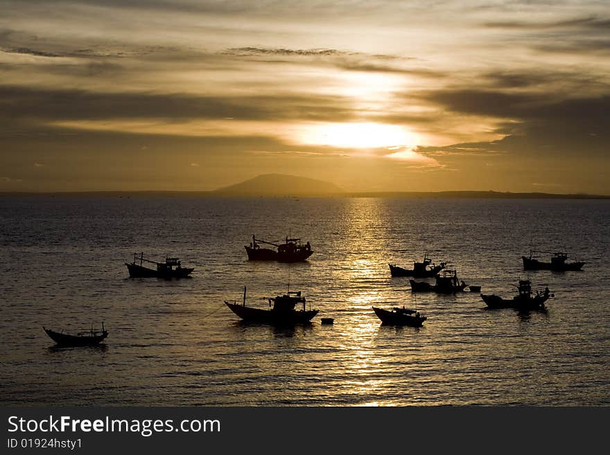 Fisher boats in a sea at sunset time