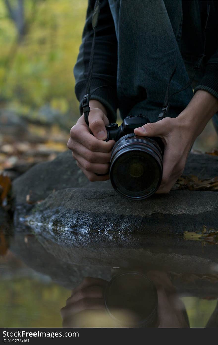 A photographer trying to use water to get a reflection shot. A photographer trying to use water to get a reflection shot