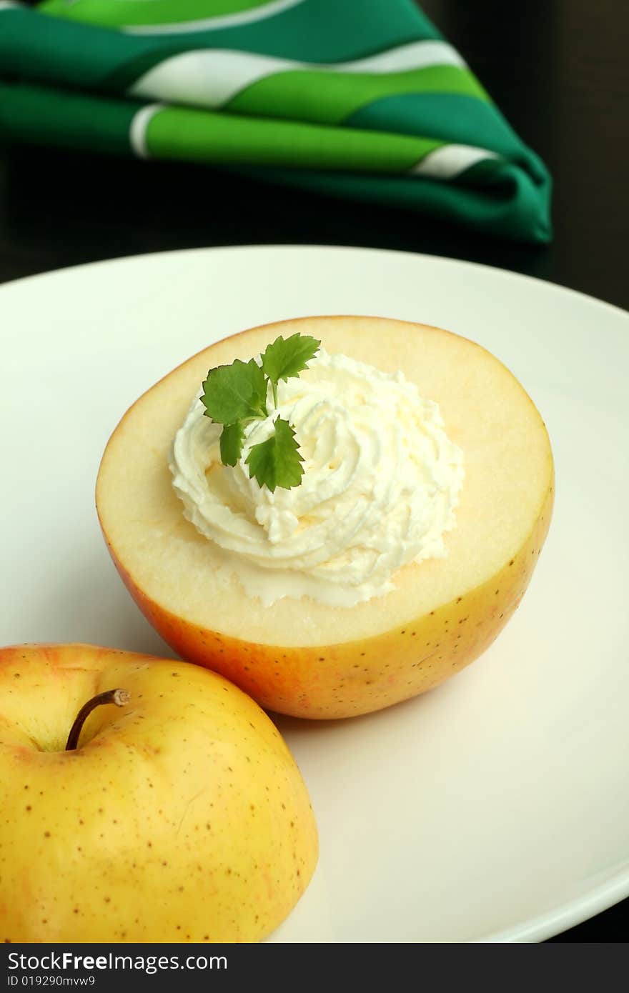 apple with whipped cream on white plate and napkin