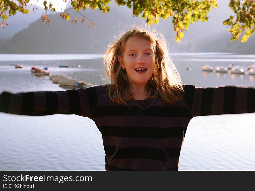 Jumping girl at the autumn lake