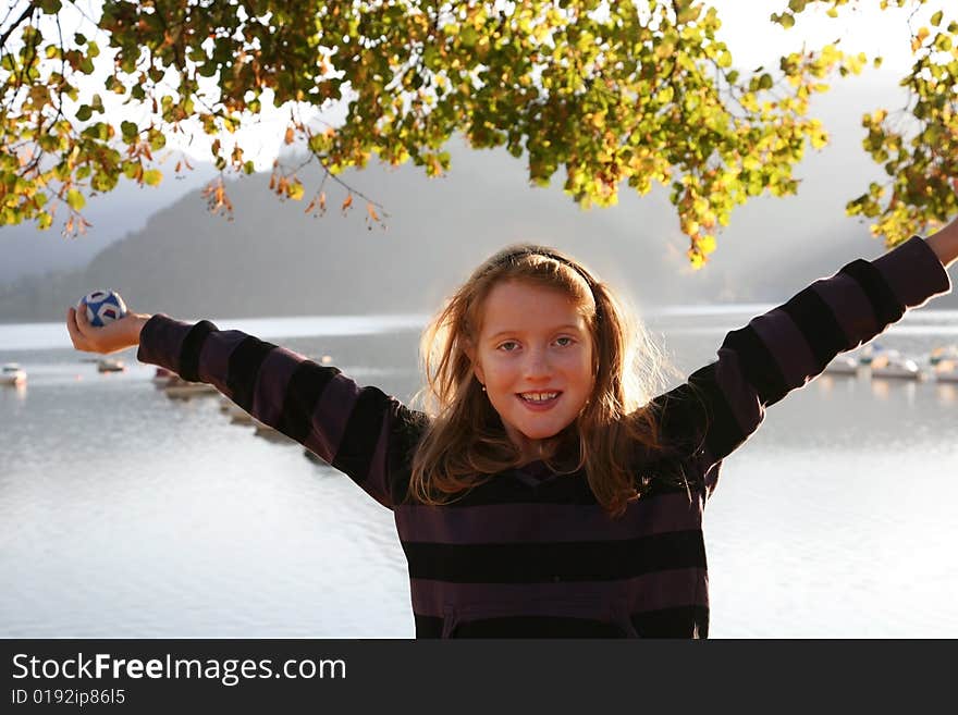 Happy girl at the autumn lake