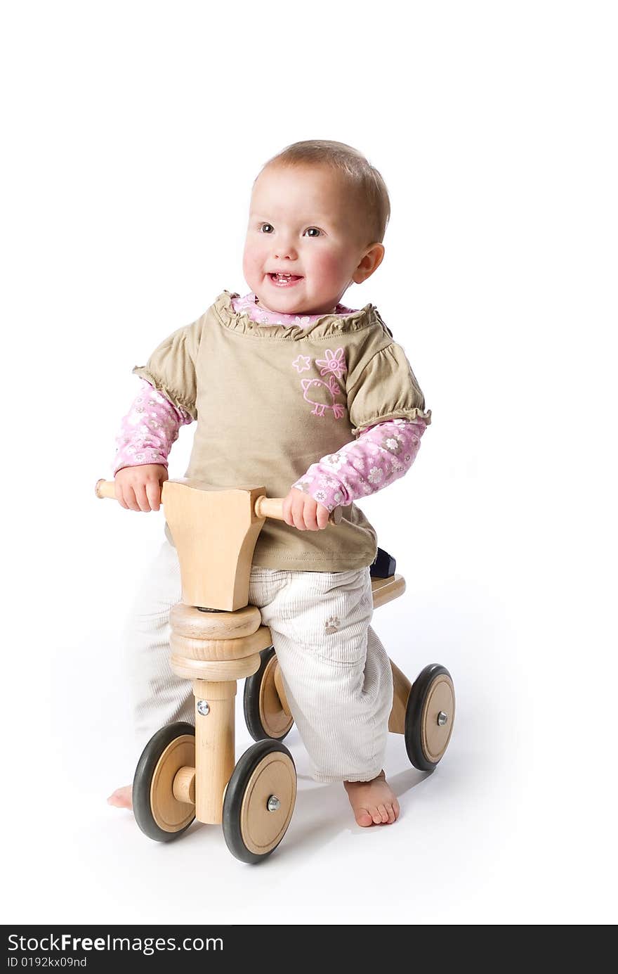 Baby girl, 1 year old, riding on bicycle, isolated on white background. Baby girl, 1 year old, riding on bicycle, isolated on white background