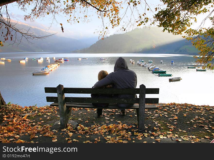 View of the lake Wägital in Swiss Alps with a family on the bench. View of the lake Wägital in Swiss Alps with a family on the bench