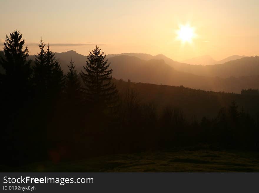 Misty and cloudy mountains silhouette with sunset pink skies. Misty and cloudy mountains silhouette with sunset pink skies