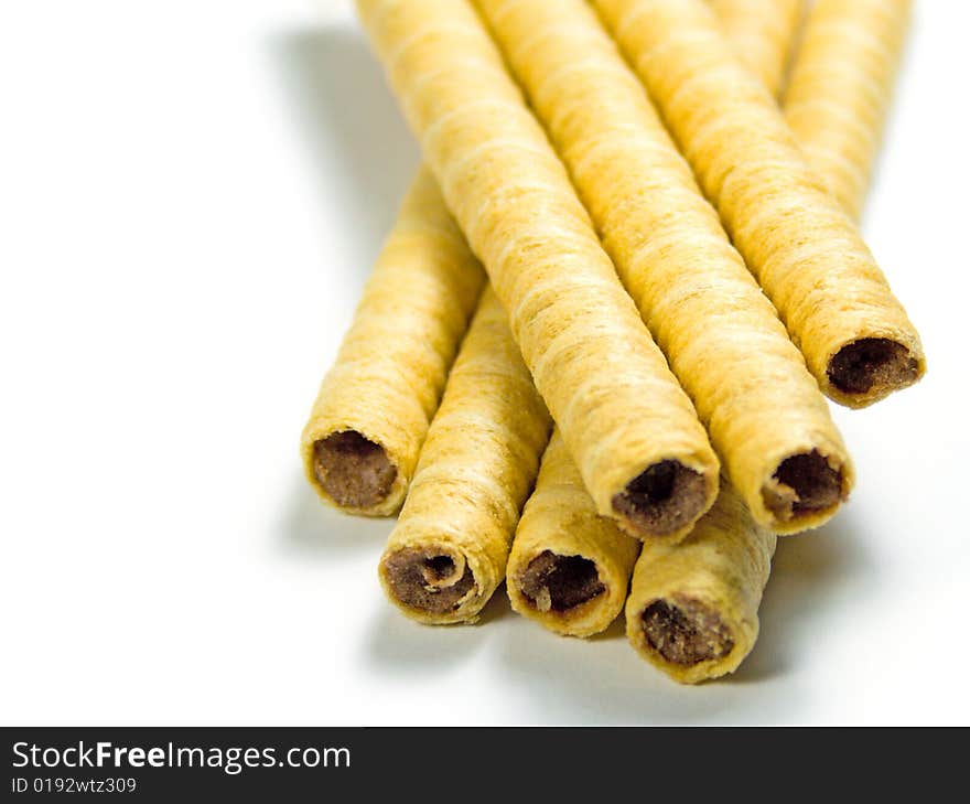 Heap of striped wafer tubules with chocolate cream