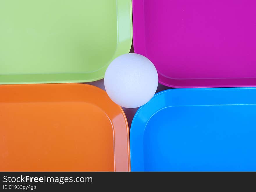 White egg among colorful plates. White egg among colorful plates