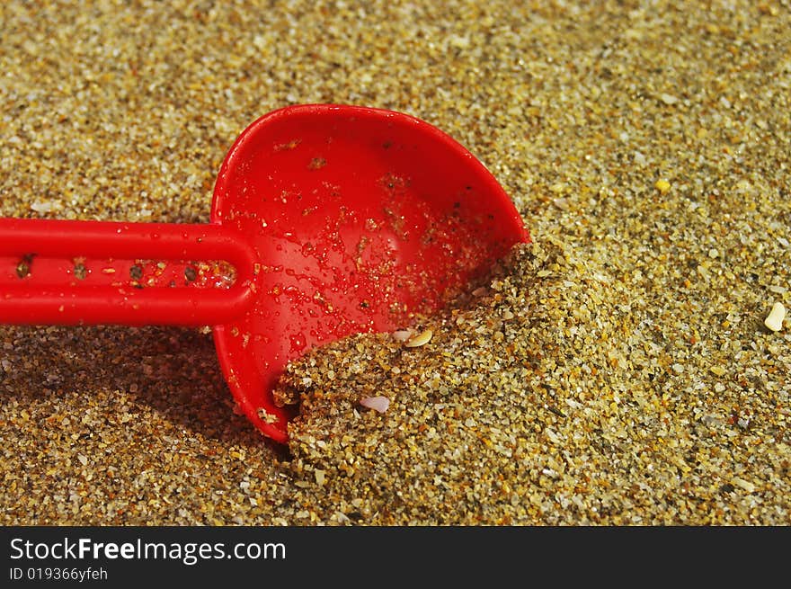 Child's toy shovel in the beach sand. Child's toy shovel in the beach sand