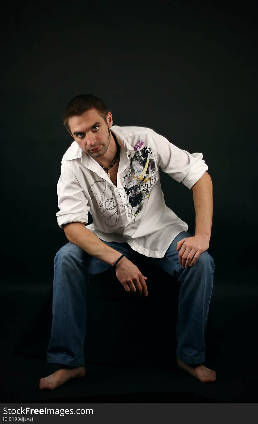 Young man in a white shirt on a black background