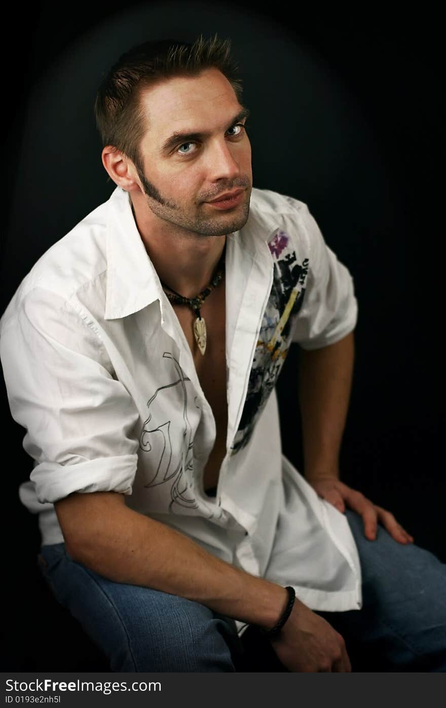 Young man in a white shirt on a black background