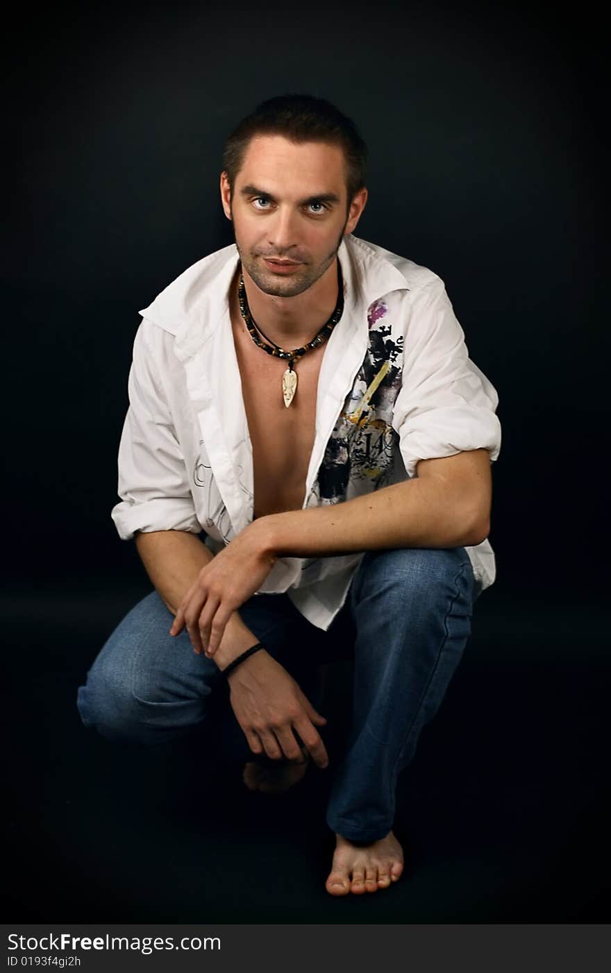 Young man in a white shirt on a black background