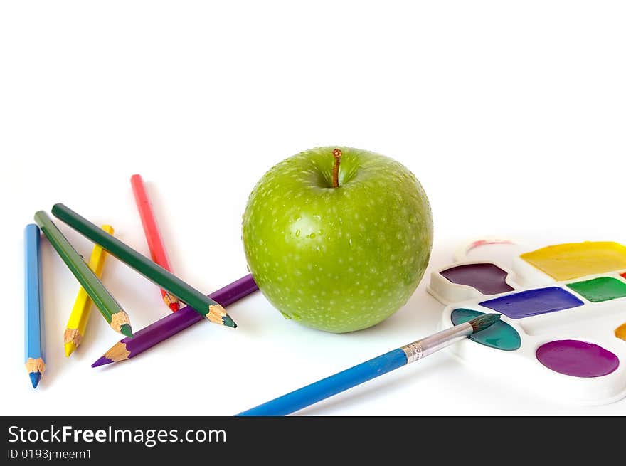 Green apple, pencils and paints isolated on white background. Green apple, pencils and paints isolated on white background