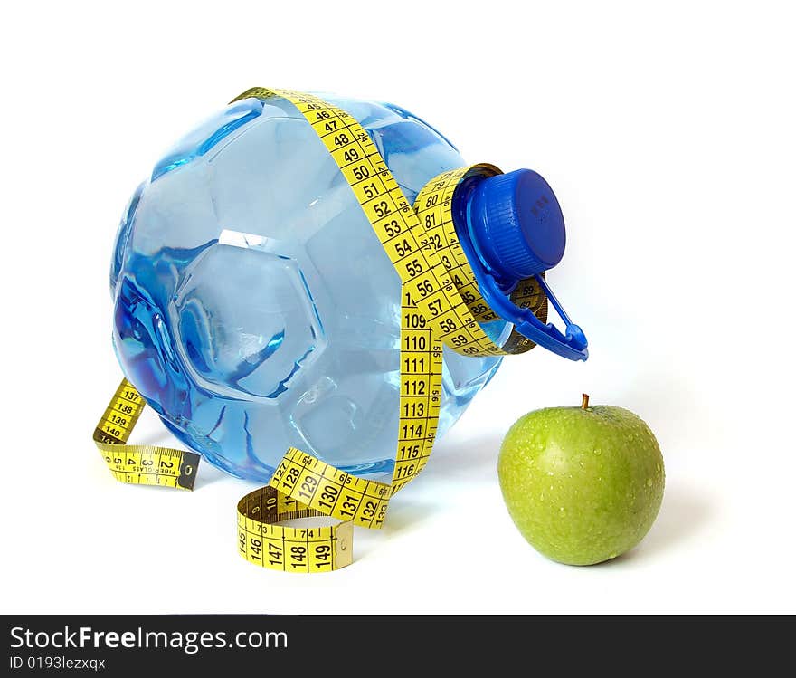 Plastic bottle of water and green apple