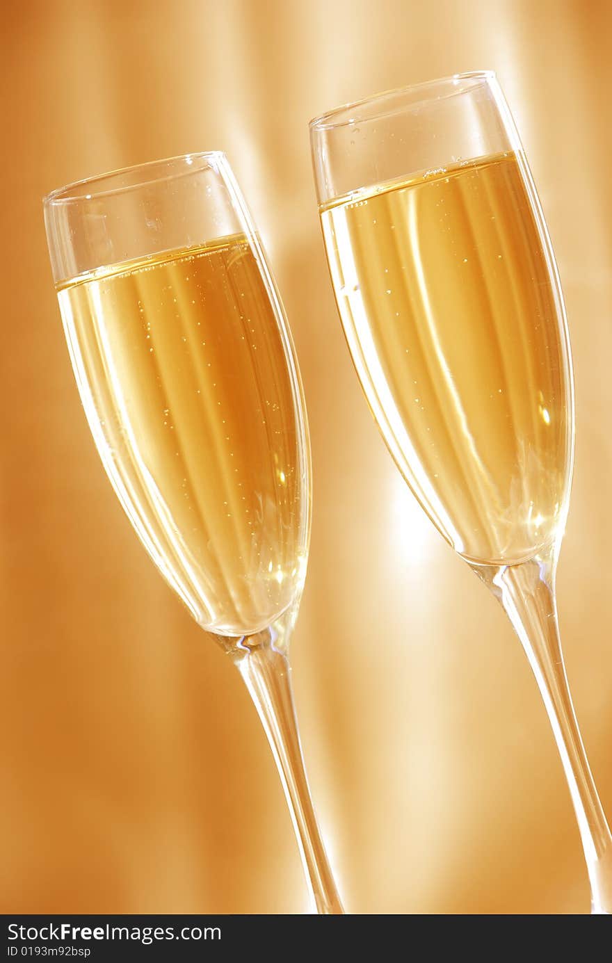 Two glasses of champagne against golden background