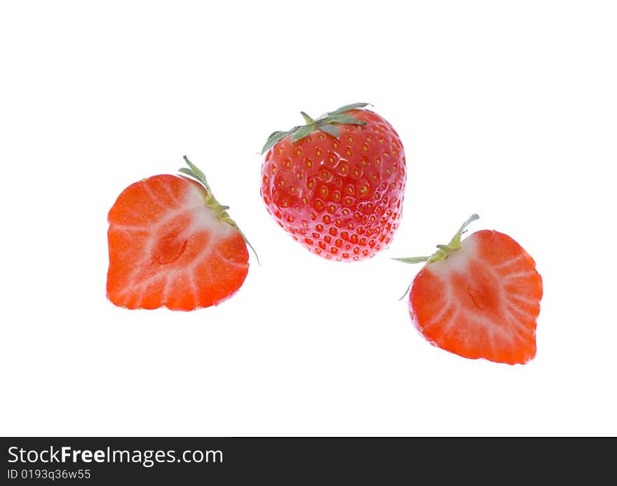 Three strawberries (two cut) on the white background