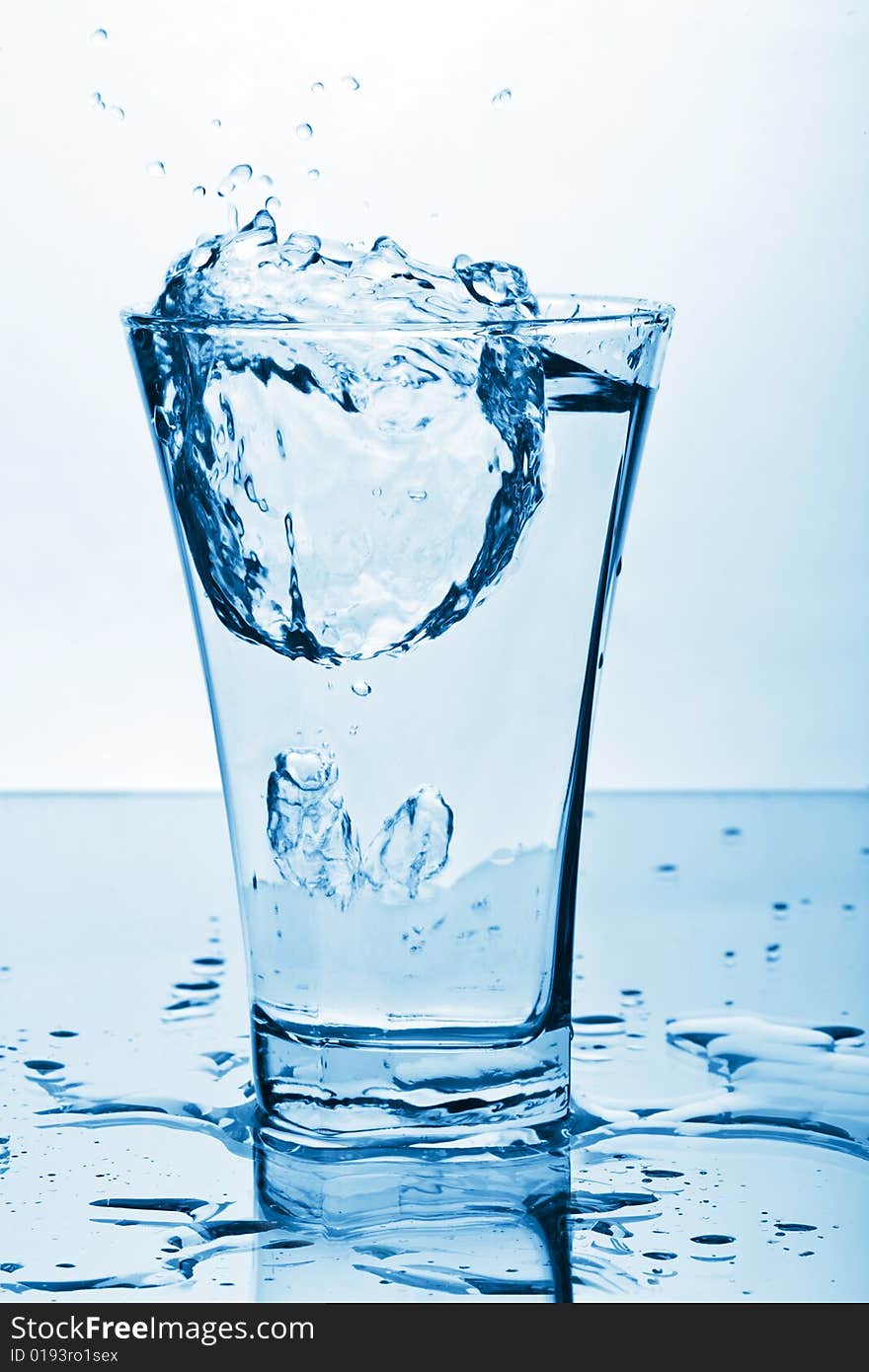 Water splashing into glass toned blue