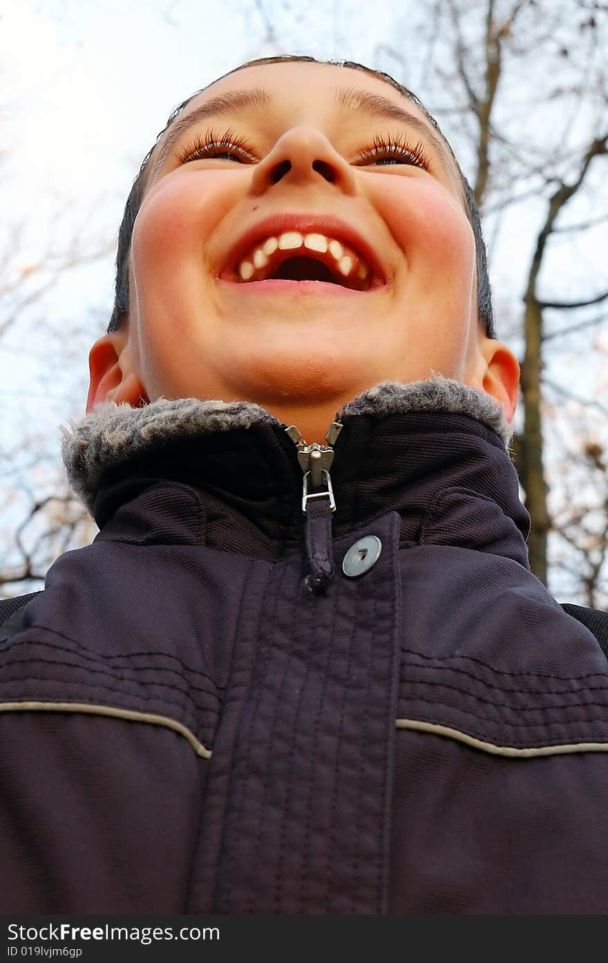 Laughing boy looking up- low angle view. Laughing boy looking up- low angle view