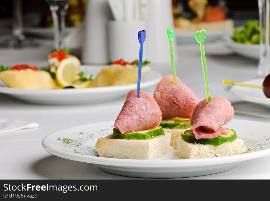 Three meat and cucumber canapes with toothpick. Three meat and cucumber canapes with toothpick