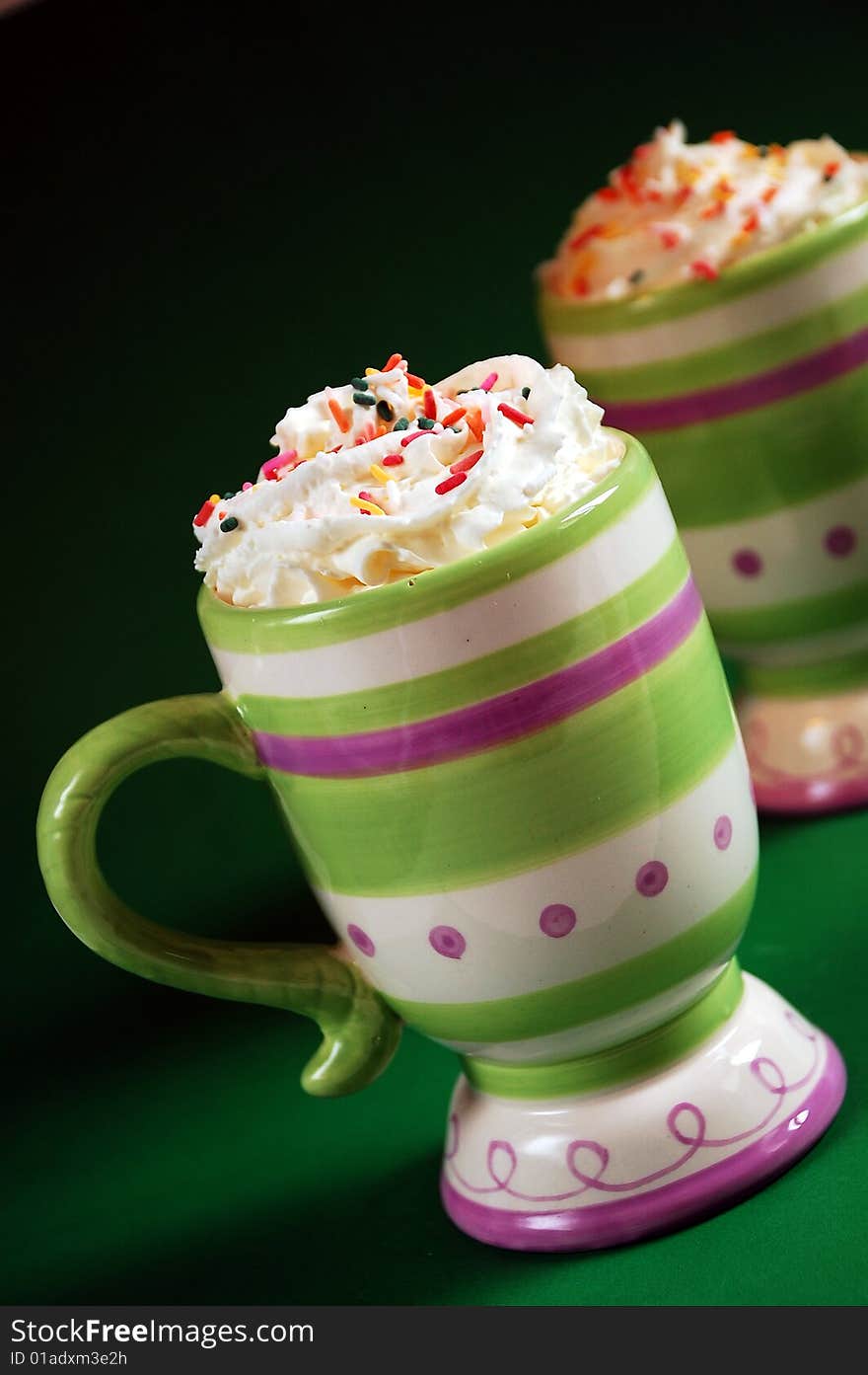 Colorful striped mug of hot cocoa and whipped cream