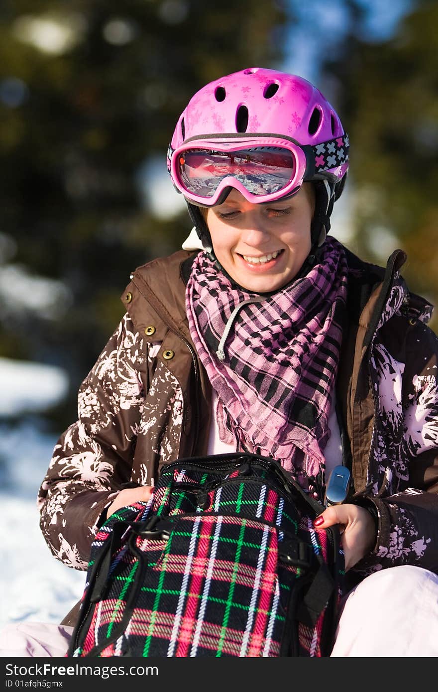 Girl with backpack sitting on snow