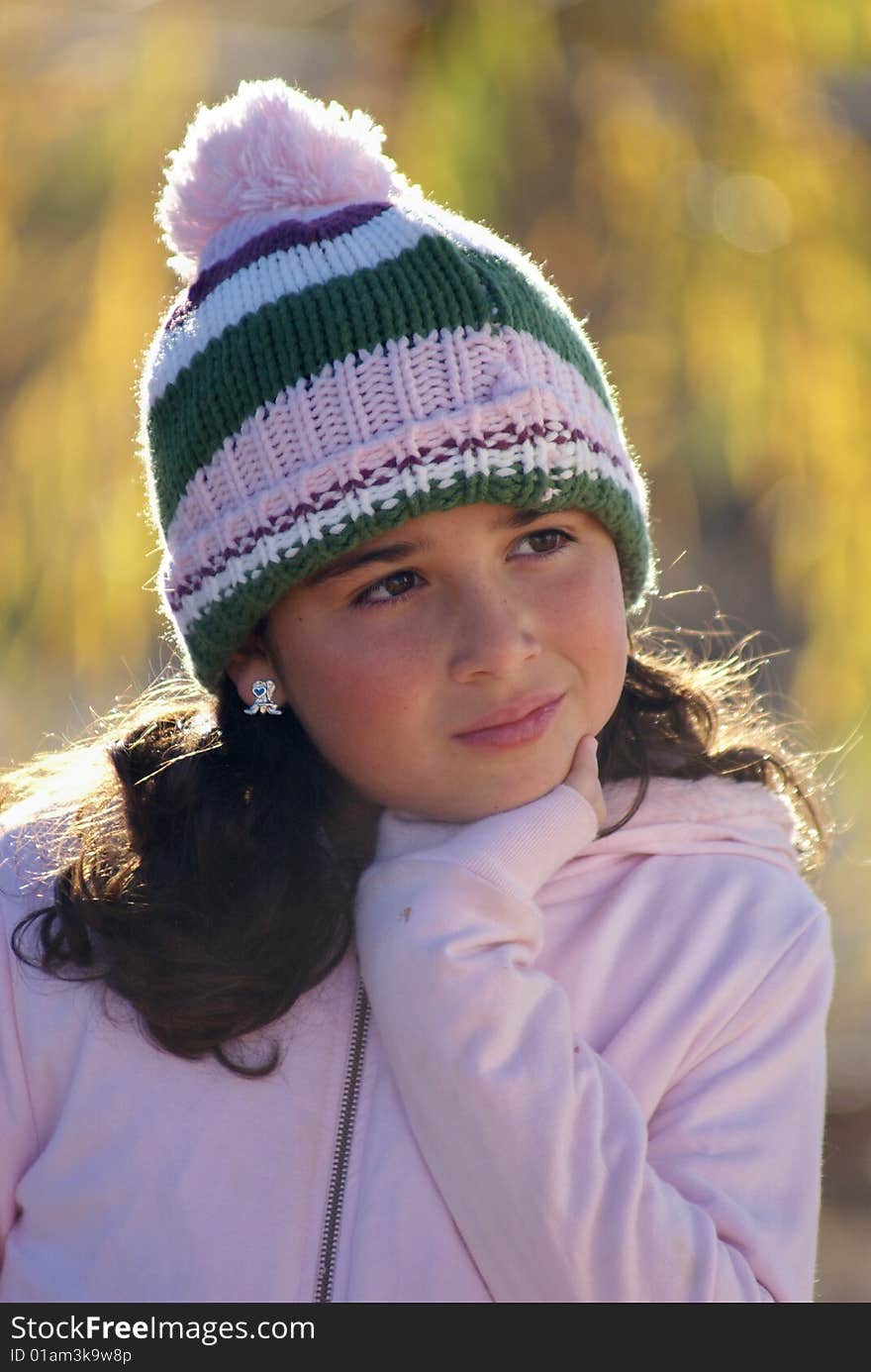 Little girl posing in ski hat and sweater on a fall or winter day. Little girl posing in ski hat and sweater on a fall or winter day