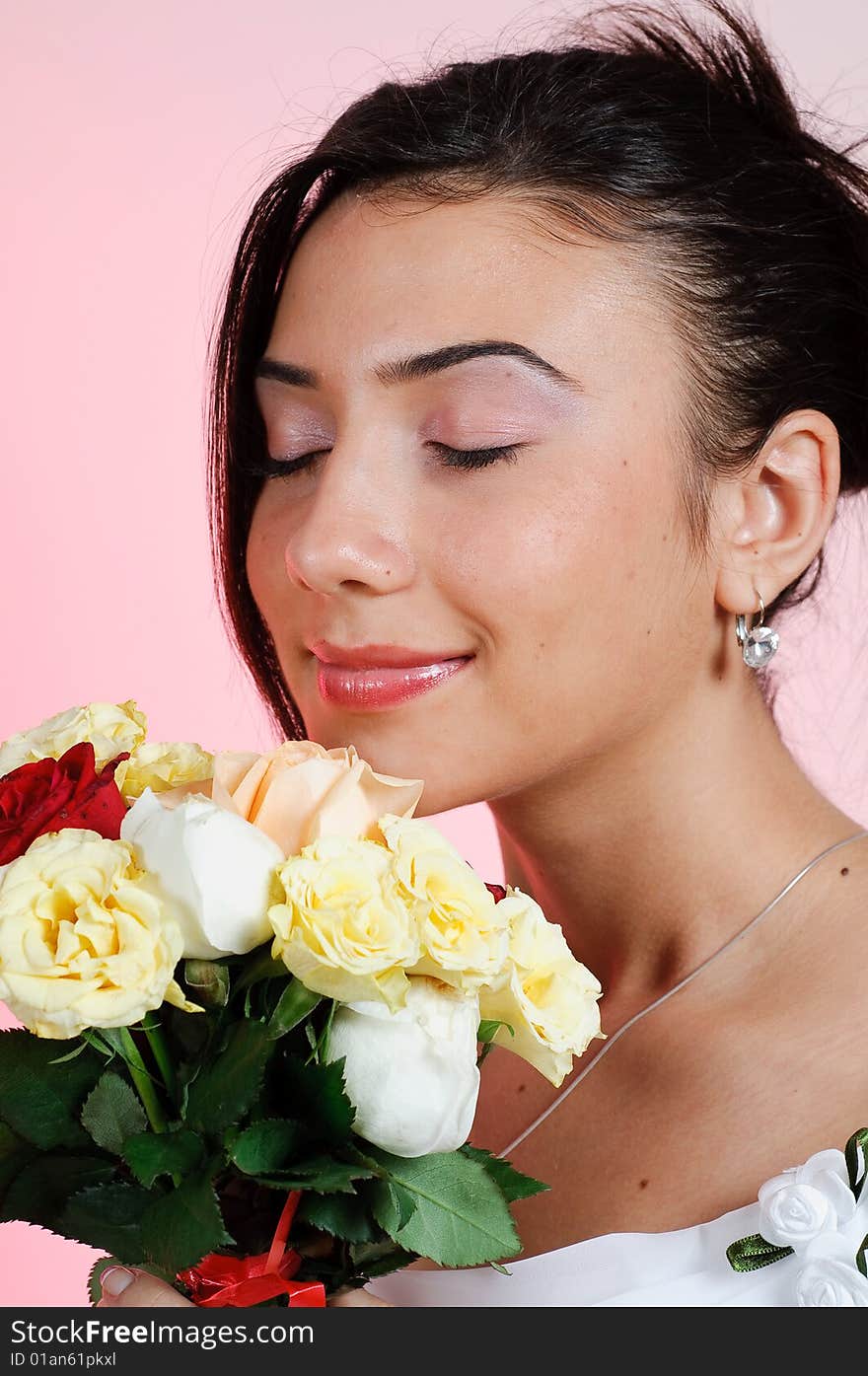 Young bride smelling roses from the wedding bouquet