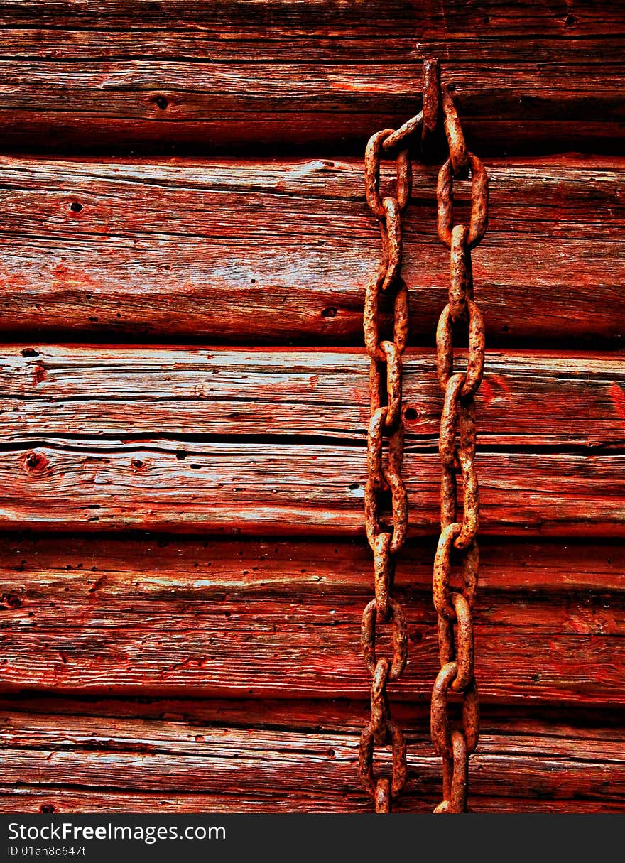 Rusted chain on red painted wooden cottage in northern sweden in skuleskogen national park