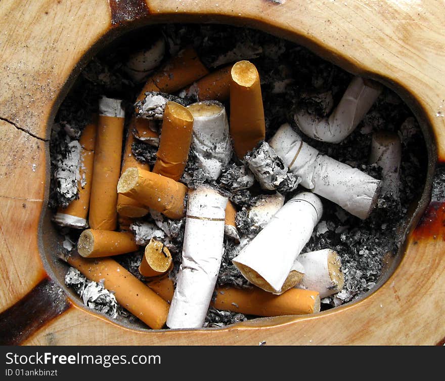 Wooden ashtray with cigarette butts